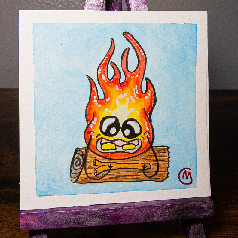 A small, original watercolor painting featuring a cartoon-style fire monster with a smiling face, painted on watercolor paper, with a white border and a purple easel.