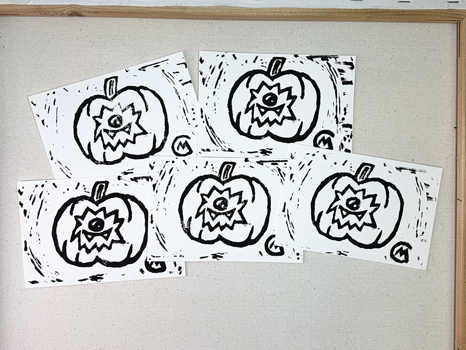 Four black and white pumpkin carving stencils on a light gray background