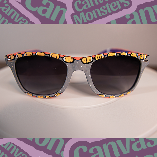 A pair of painted sunglasses with teeth patterns on the frame, displayed on a white background with 'Canvas Monsters' text.