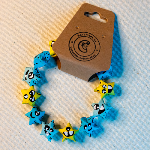 Bracelet with  blue and yellow paper origami star-shaped charms on a beige background