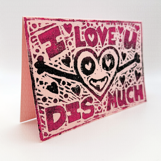 Pink greeting card with a stamped design on the front. The message says "I love you dis much" with a heart character smiling and open arms, as if reaching for a hug.
