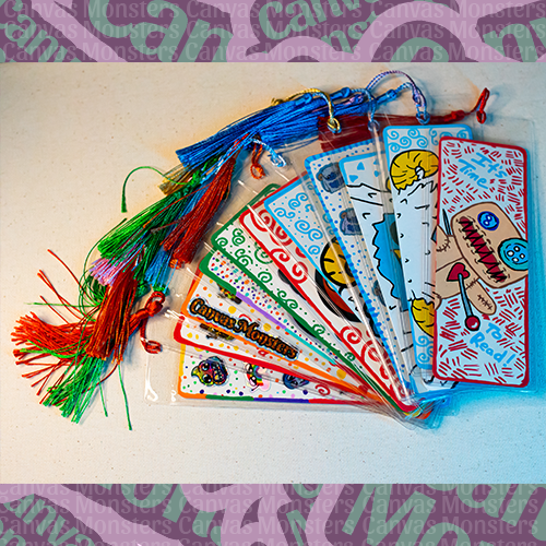 Collection of painted bookmarks with tassels on a white surface