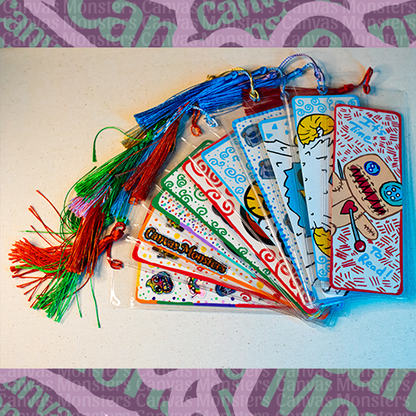 Collection of painted bookmarks with tassels on a white surface