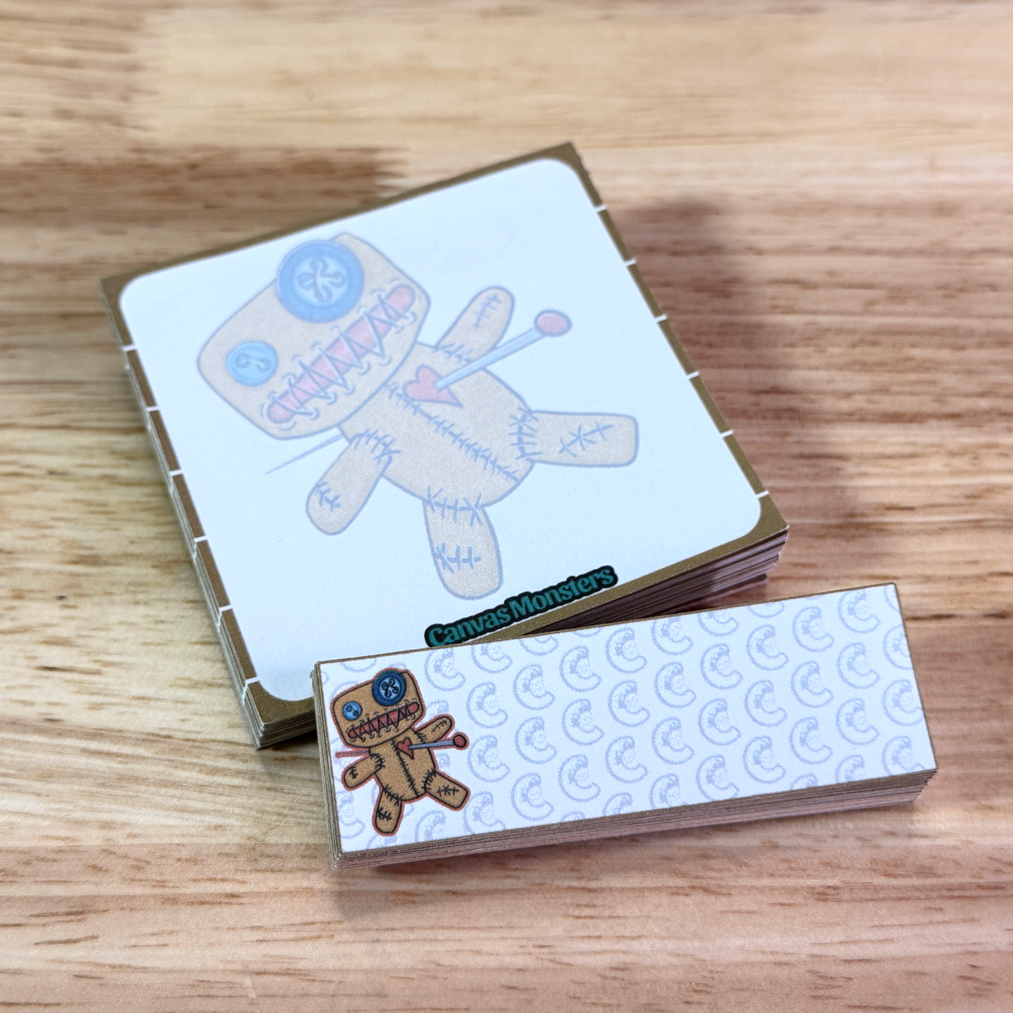 Sticky notepad set, one 3x3 and one 1x3, sitting on a wooden surface