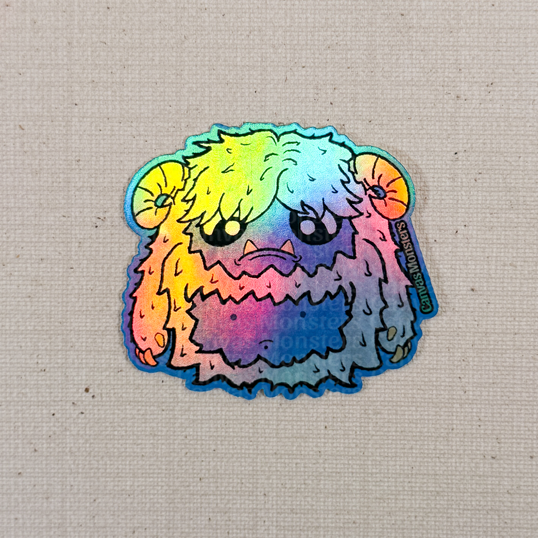 Holofoil sticker of a cartoon yeti creature with white fur and horns on a textured beige background
