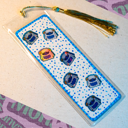 Bookmark decorated with mini Eddie the Yeti Canvas Monsters stickers with a blue polka dot background on white paper, in a plastic sleeve with a gold and blue tassel.