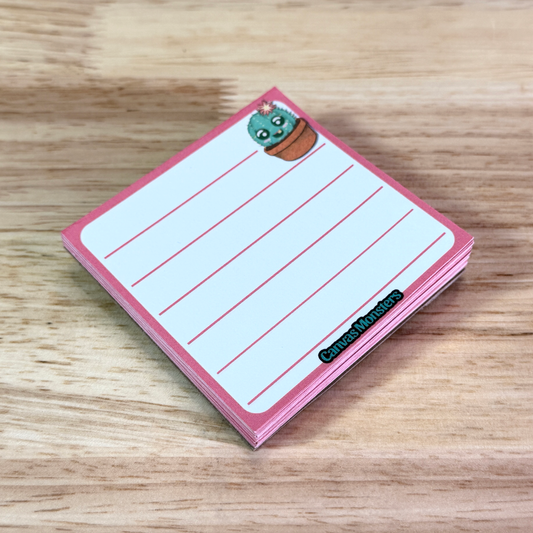 3x3 inch lined memo pad with a cartoon cactus character in the top right corner and 'Canvas Monsters' branding at the bottom, sitting on a wooden surface.