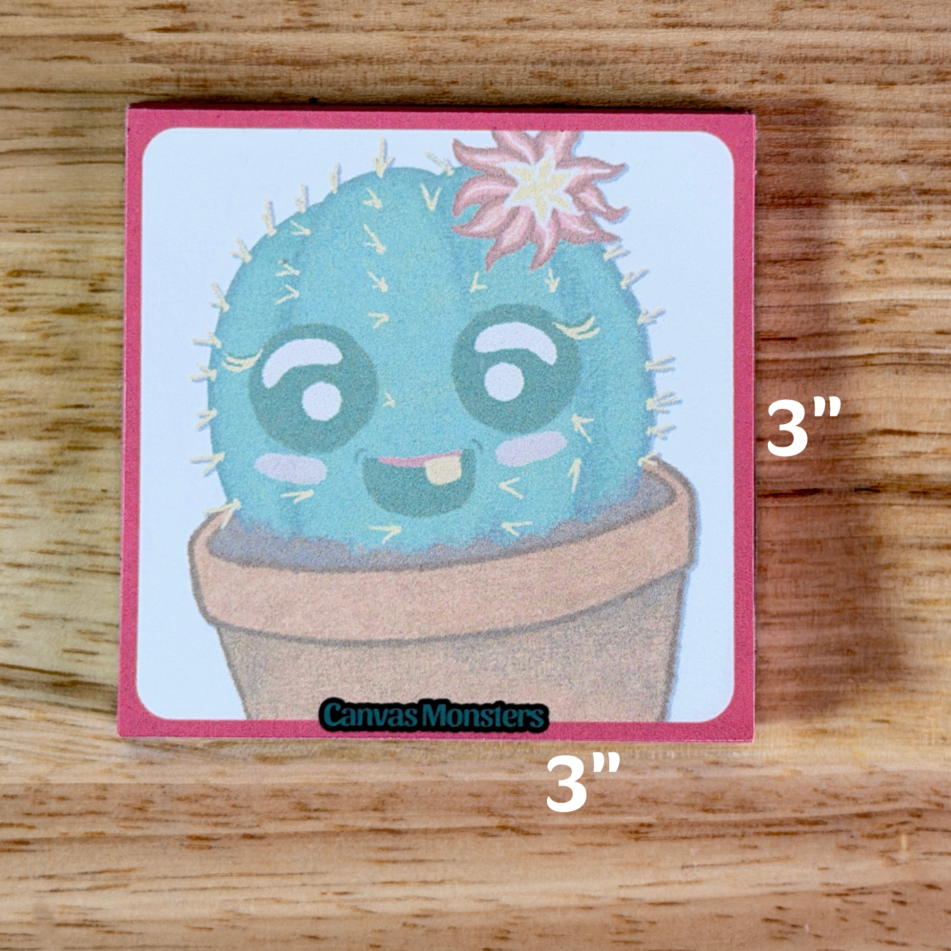 Sticky notepad with a cartoon cactus with a flower, sitting on a wooden surface.