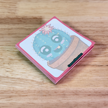 Sticky notepad with a cactus cartoon, sitting on a wooden surface