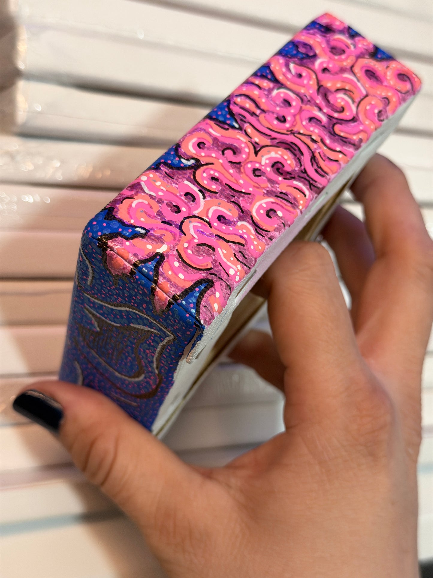 Top view of an acrylic block painting, showing the pink brains. Painting being held by a hand in front of a white background.