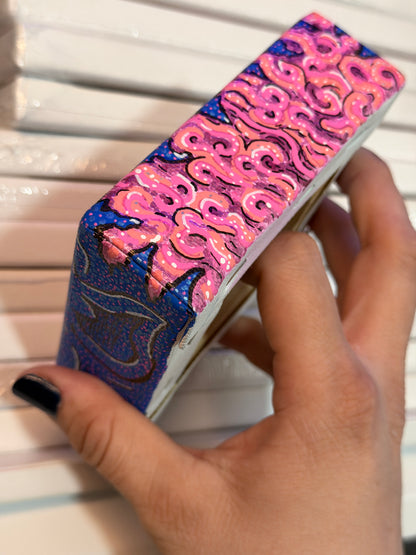 Top view of an acrylic block painting, showing the pink brains. Painting being held by a hand in front of a white background.
