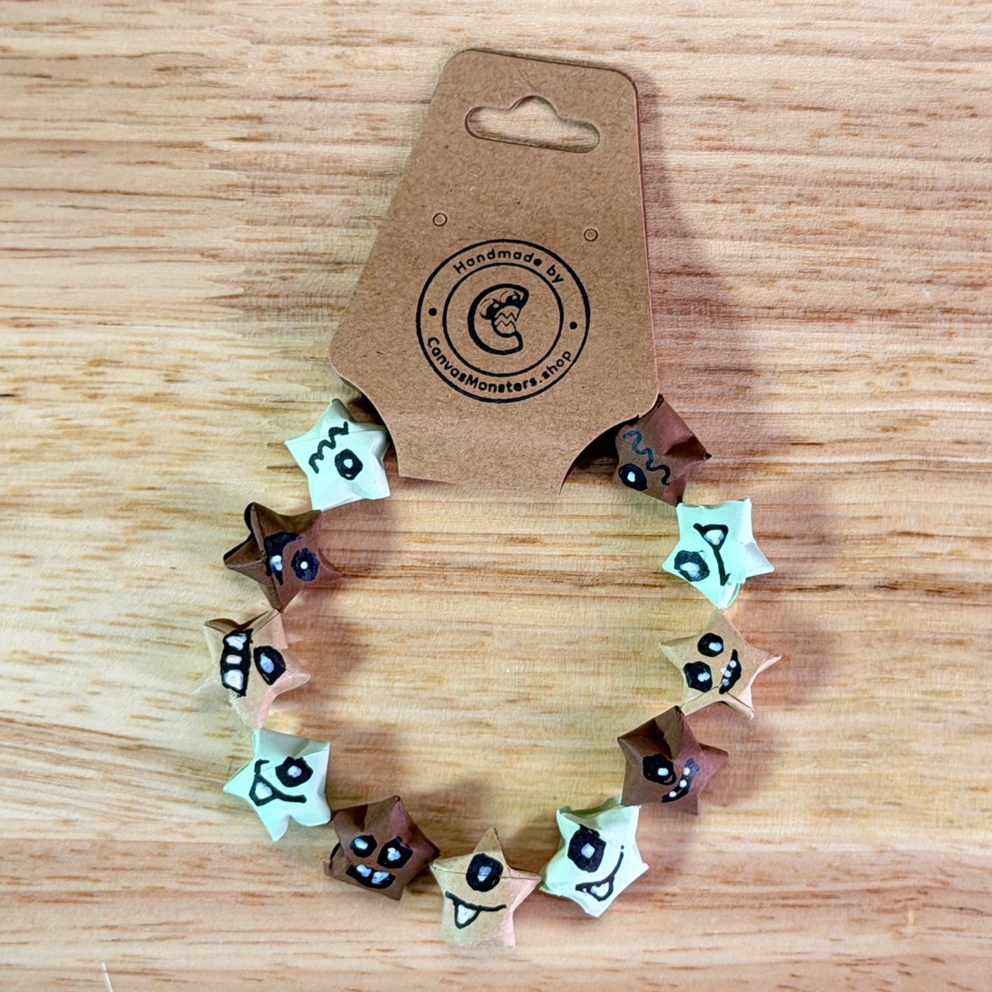 Bracelet with blue and tan paper origami star-shaped charms on a wooden background