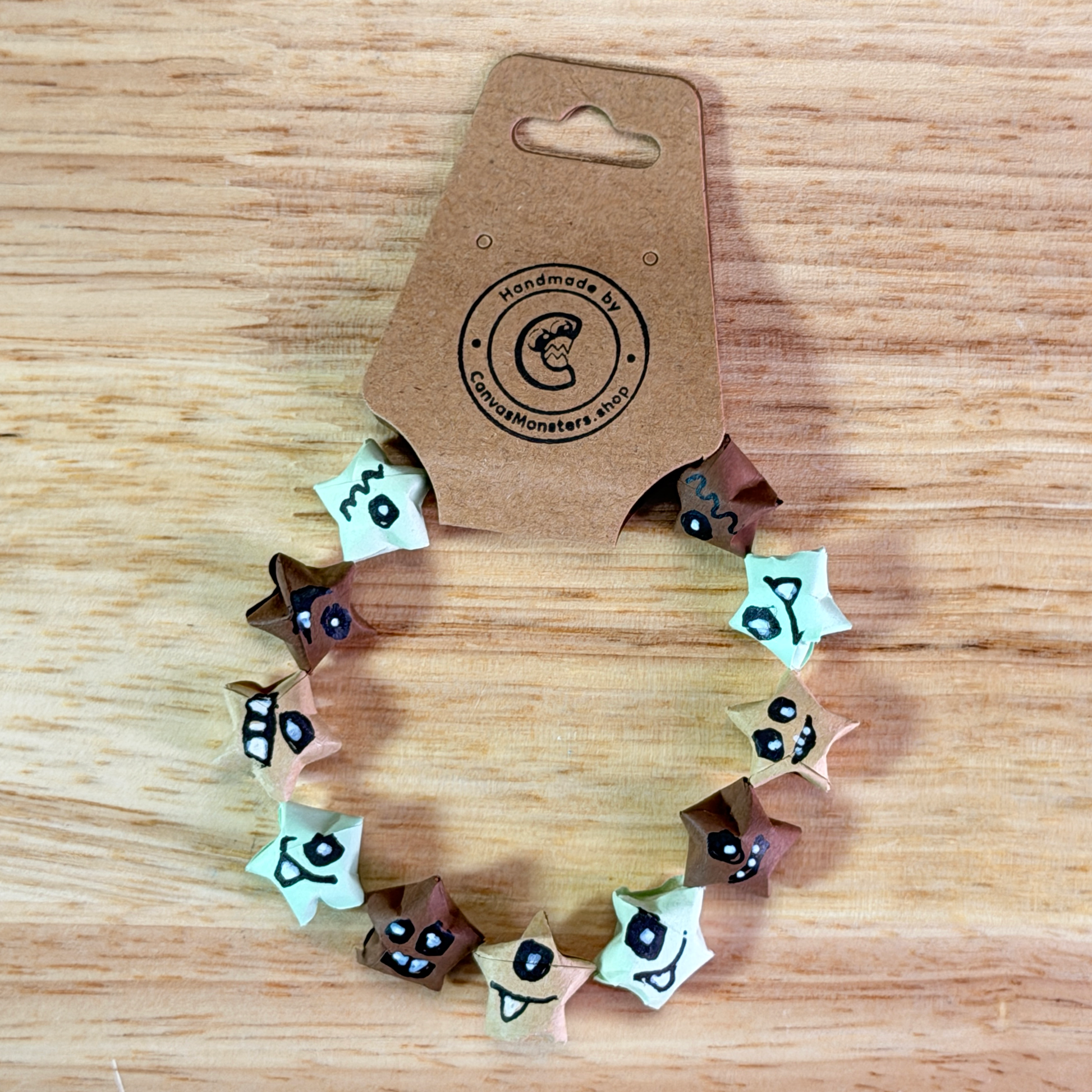 Bracelet with blue and tan paper origami star-shaped charms on a wooden background