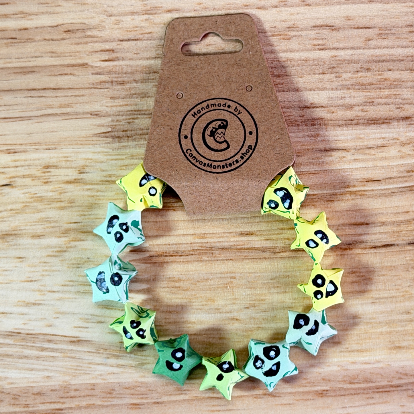 Bracelet with yellow, blue, and green paper origami star-shaped charms on a wooden background