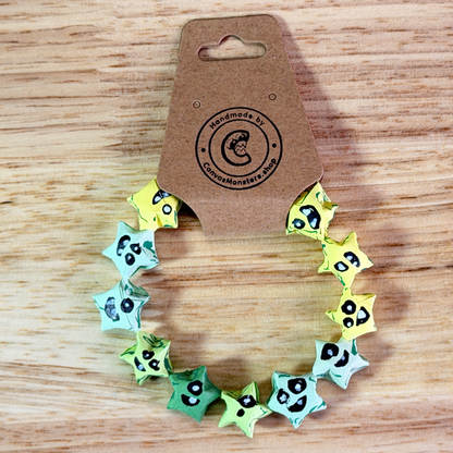 Bracelet with yellow, blue, and green paper origami star-shaped charms on a wooden background