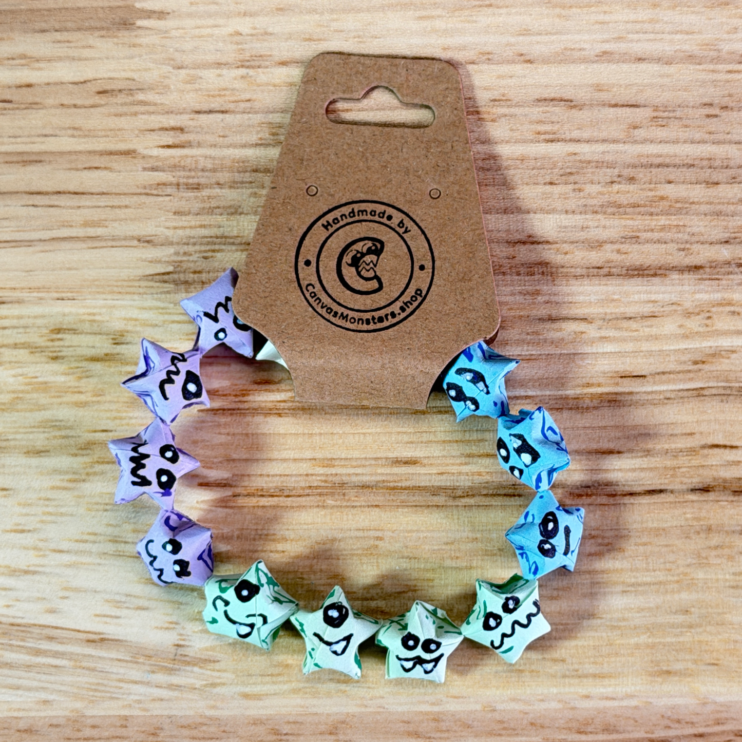 Bracelet with colorful paper origami star-shaped charms on a wooden background