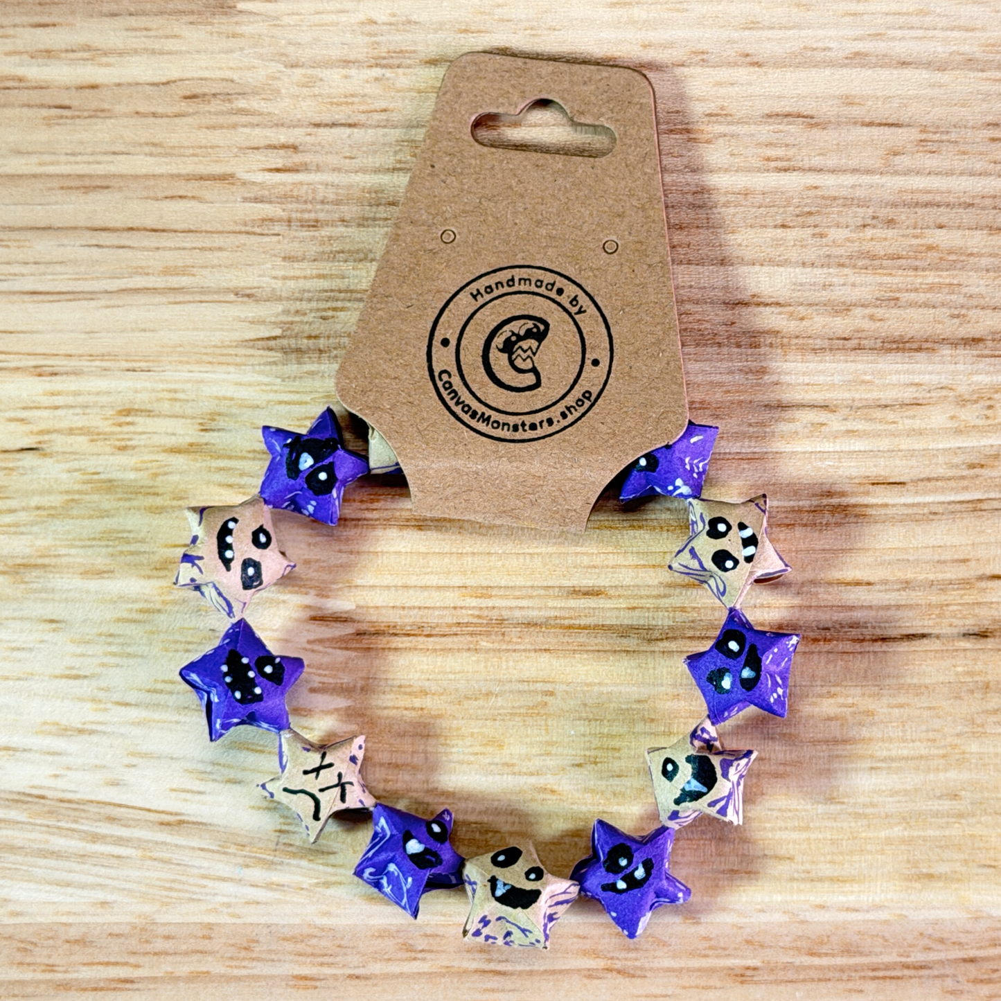 Bracelet with alternating blue and tan paper origami star-shaped charms on a wooden background