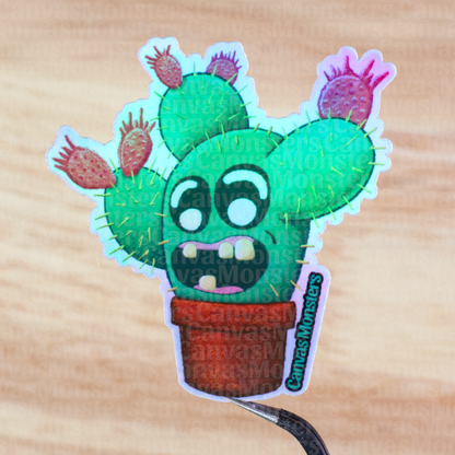 Holofoil sticker of a cartoon cactus character with a surprised expression held above a wooden surface