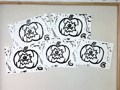 Four black and white pumpkin carving stencils on a light gray background