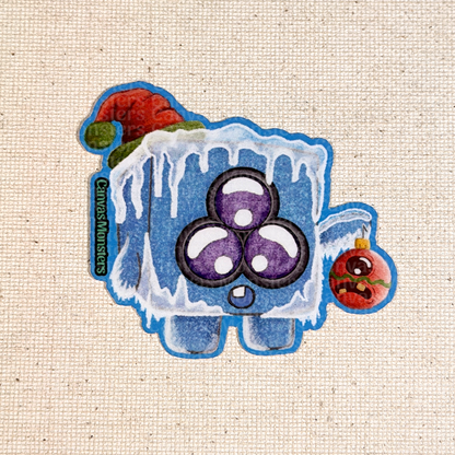 Glossy sticker of an ice cube character on a beige fabric background