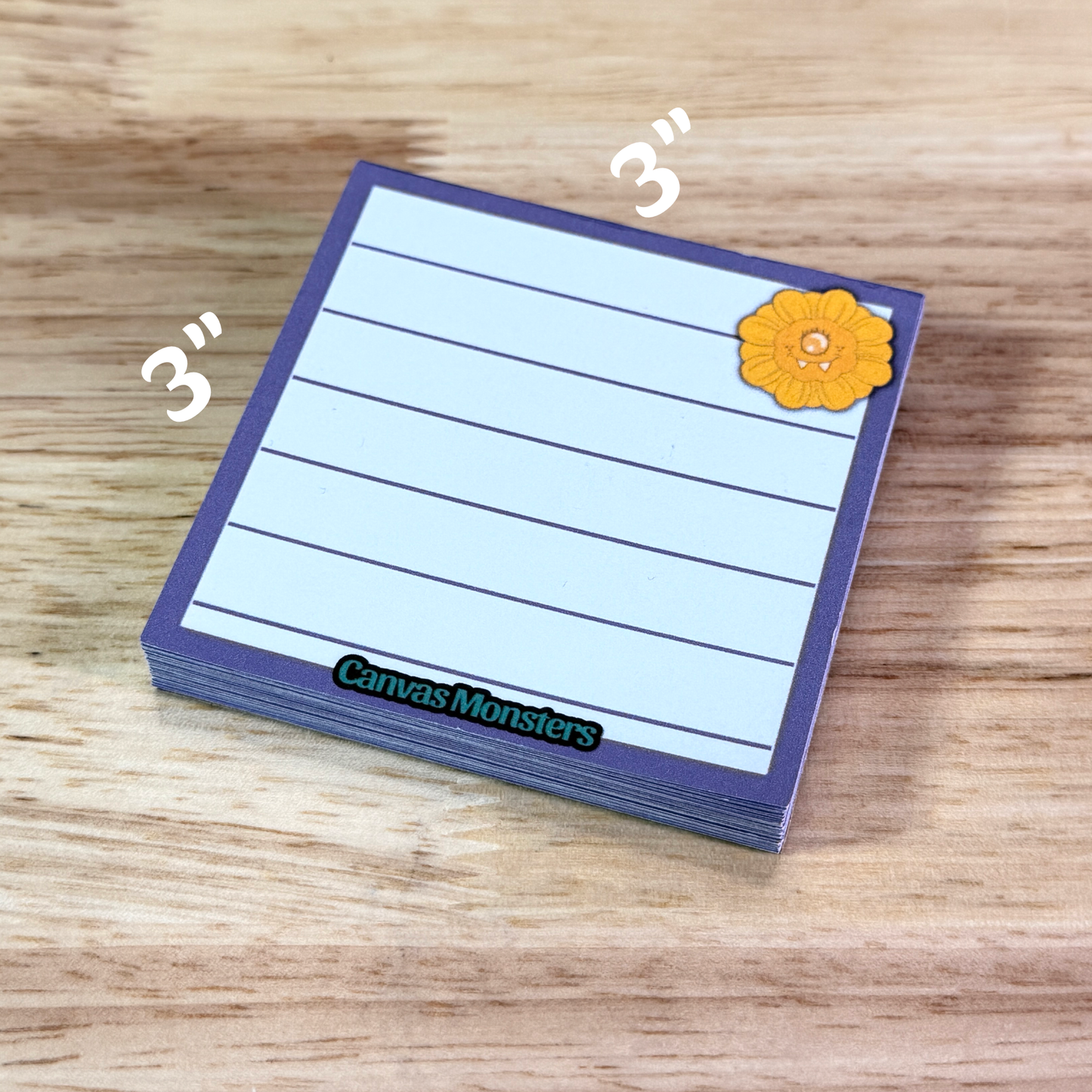 3x3 inch memo pad with a purple border and a sunflower cartoon character in the top right corner, sitting on a wooden background.