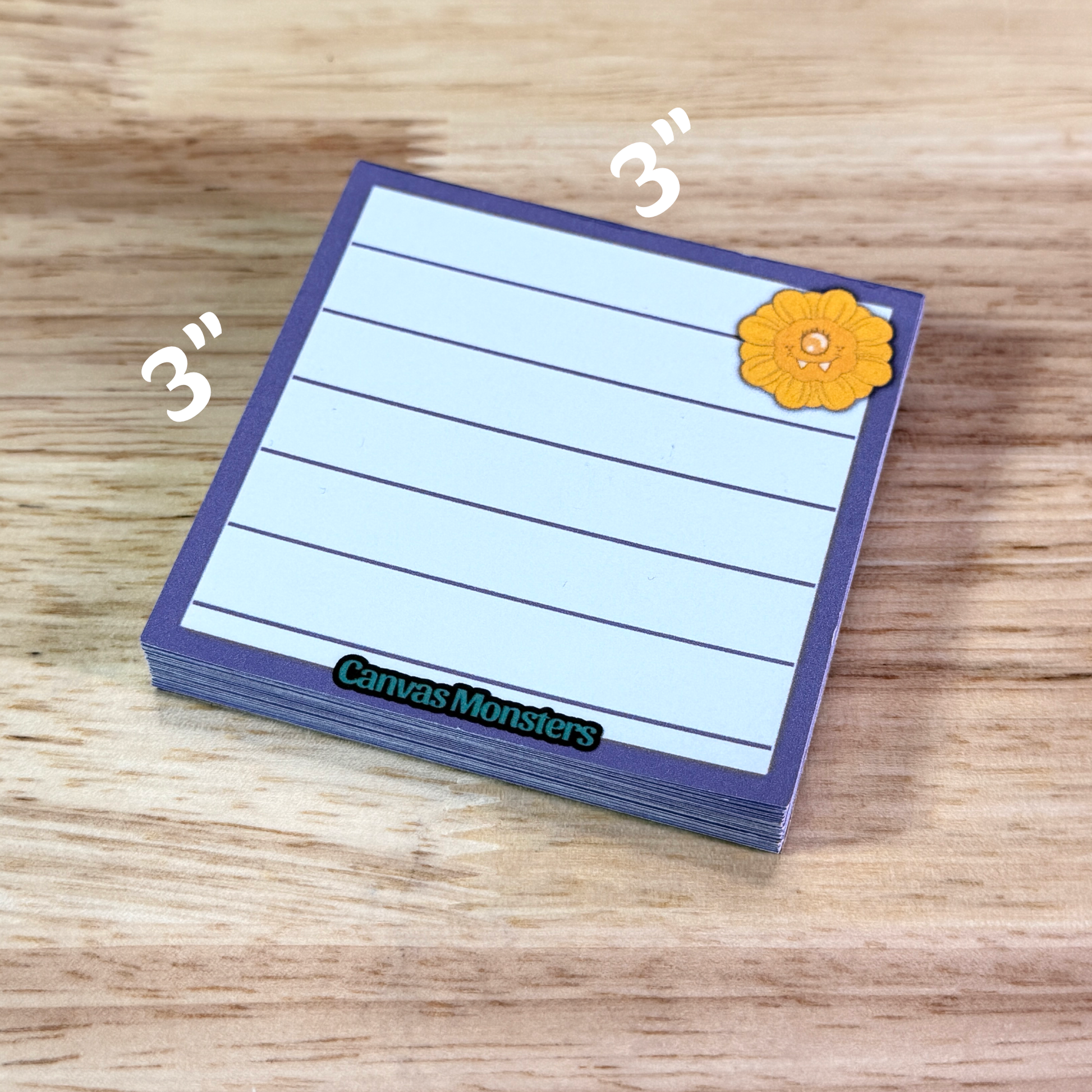 3x3 inch memo pad with a purple border and a sunflower cartoon character in the top right corner, sitting on a wooden background.