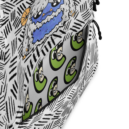 Close-up of a patterned zippered pouch or bag, showing a black-and-white hand-drawn sketch style exterior with a blue and orange cartoon face, and a gray interior lined with green cartoon eyes.