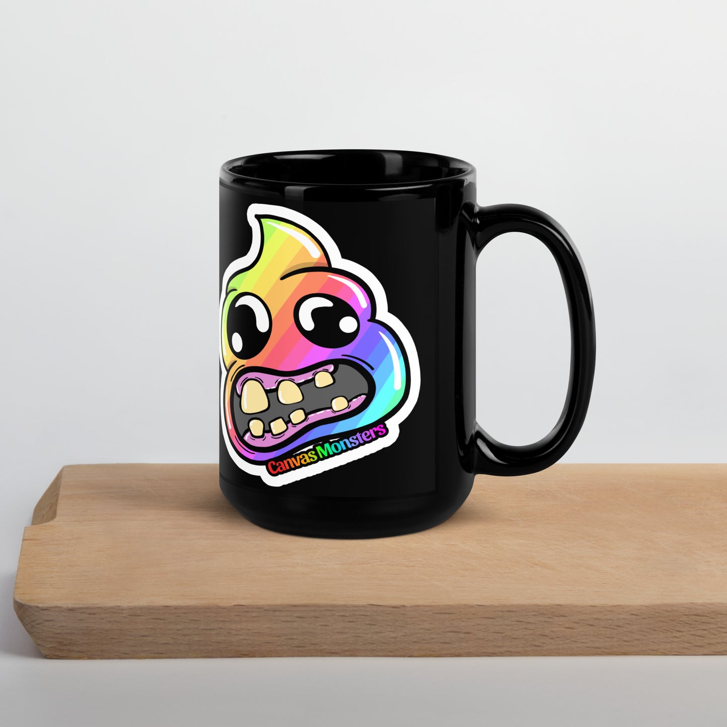 Black mug with a colorful monster design on a wooden surface