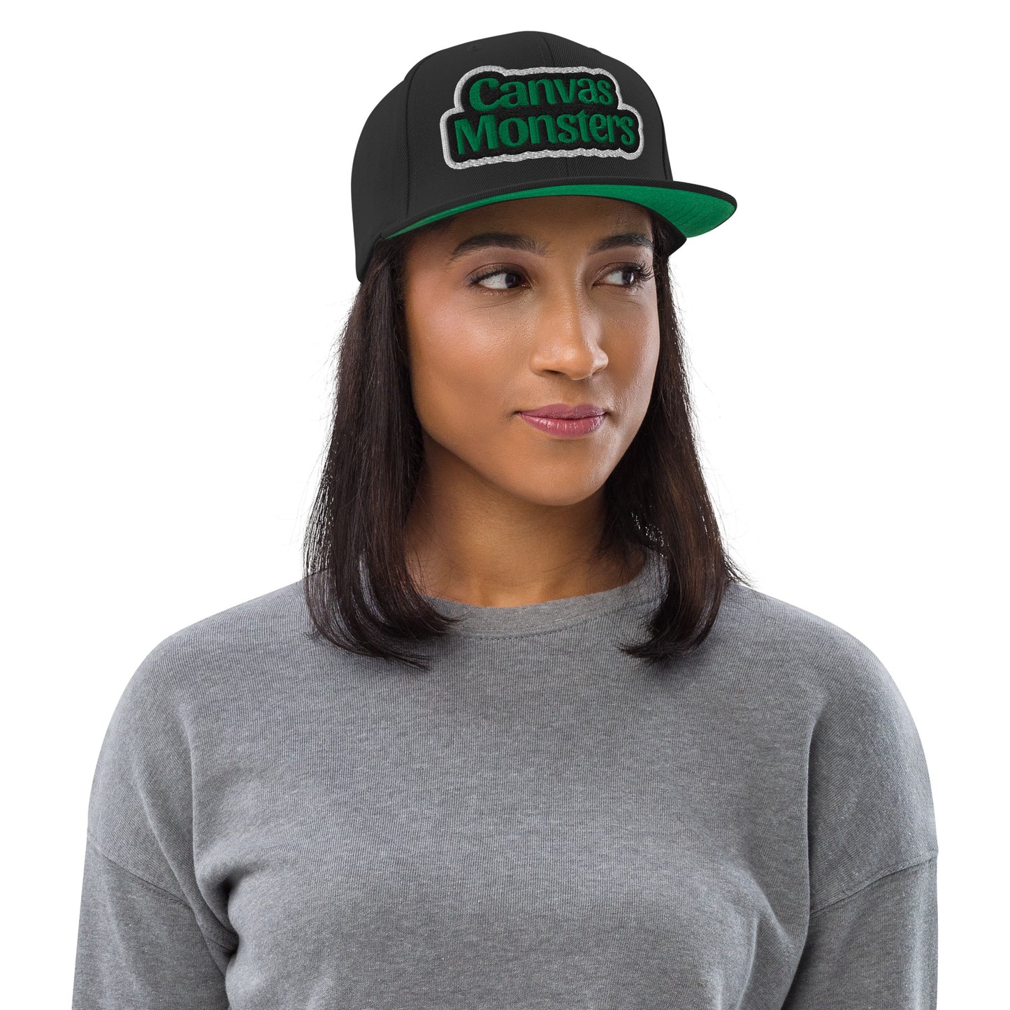 Woman wearing a black cap with 'Canvas Monsters' logo on a white background
