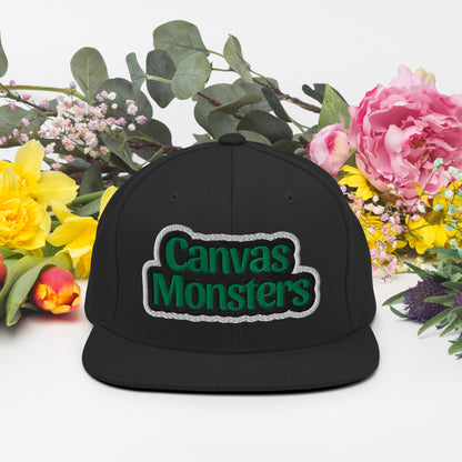 Black cap with 'Canvas Monsters' logo surrounded by flowers on a white background