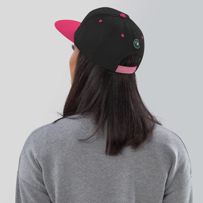 Person wearing a black and pink cap with a logo on a plain background