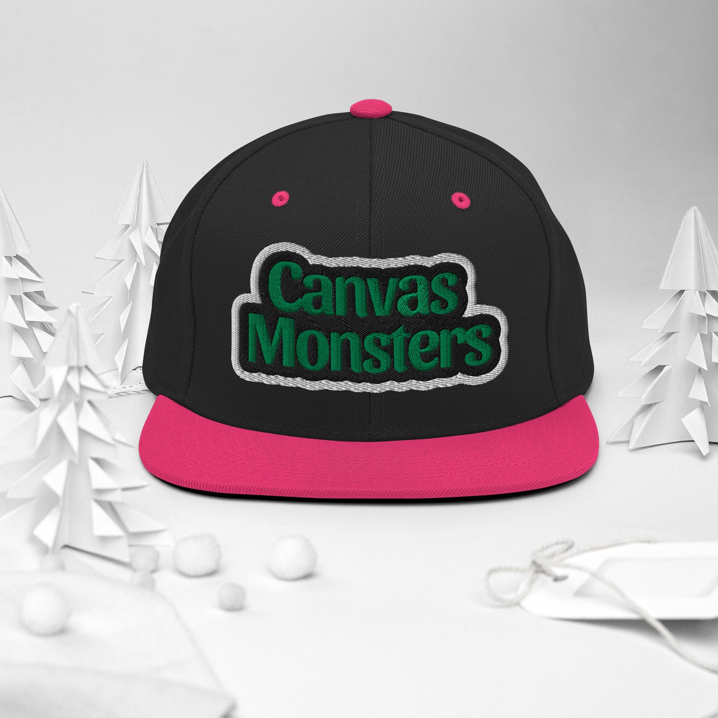 Black and pink cap with 'Canvas Monsters' text on a white background