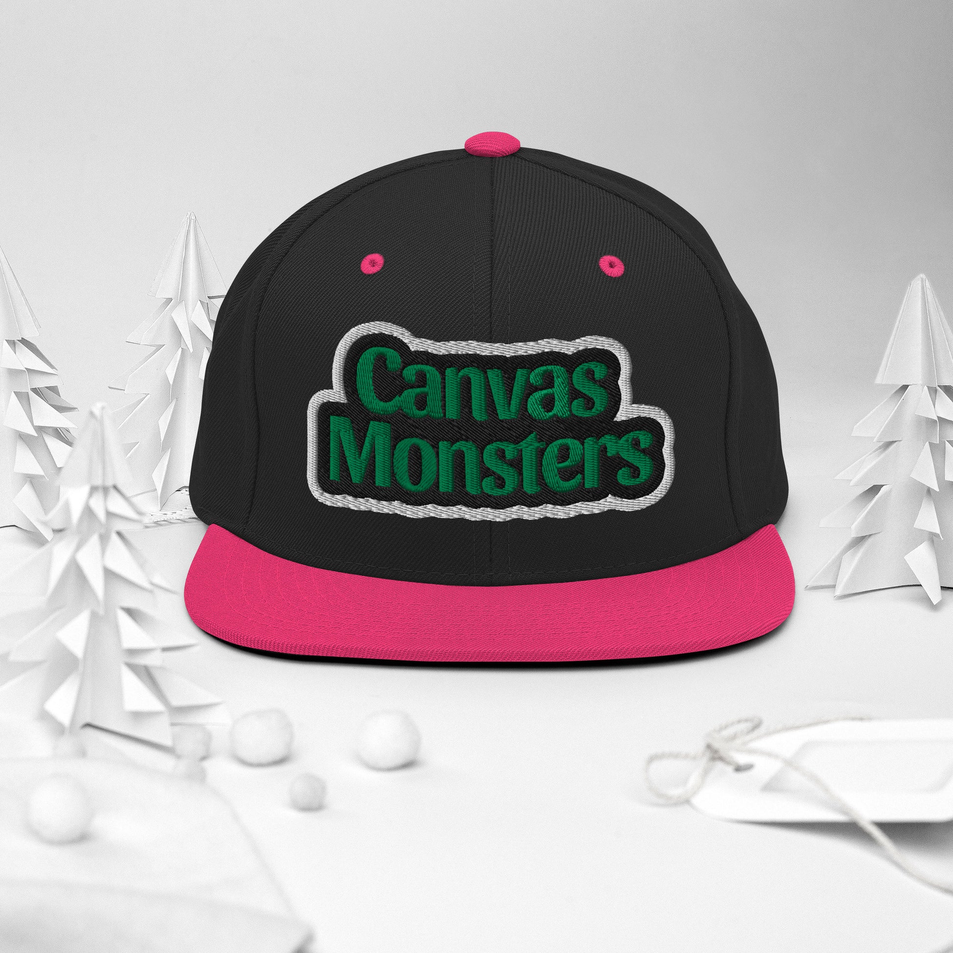 Black and pink cap with 'Canvas Monsters' text on a white background