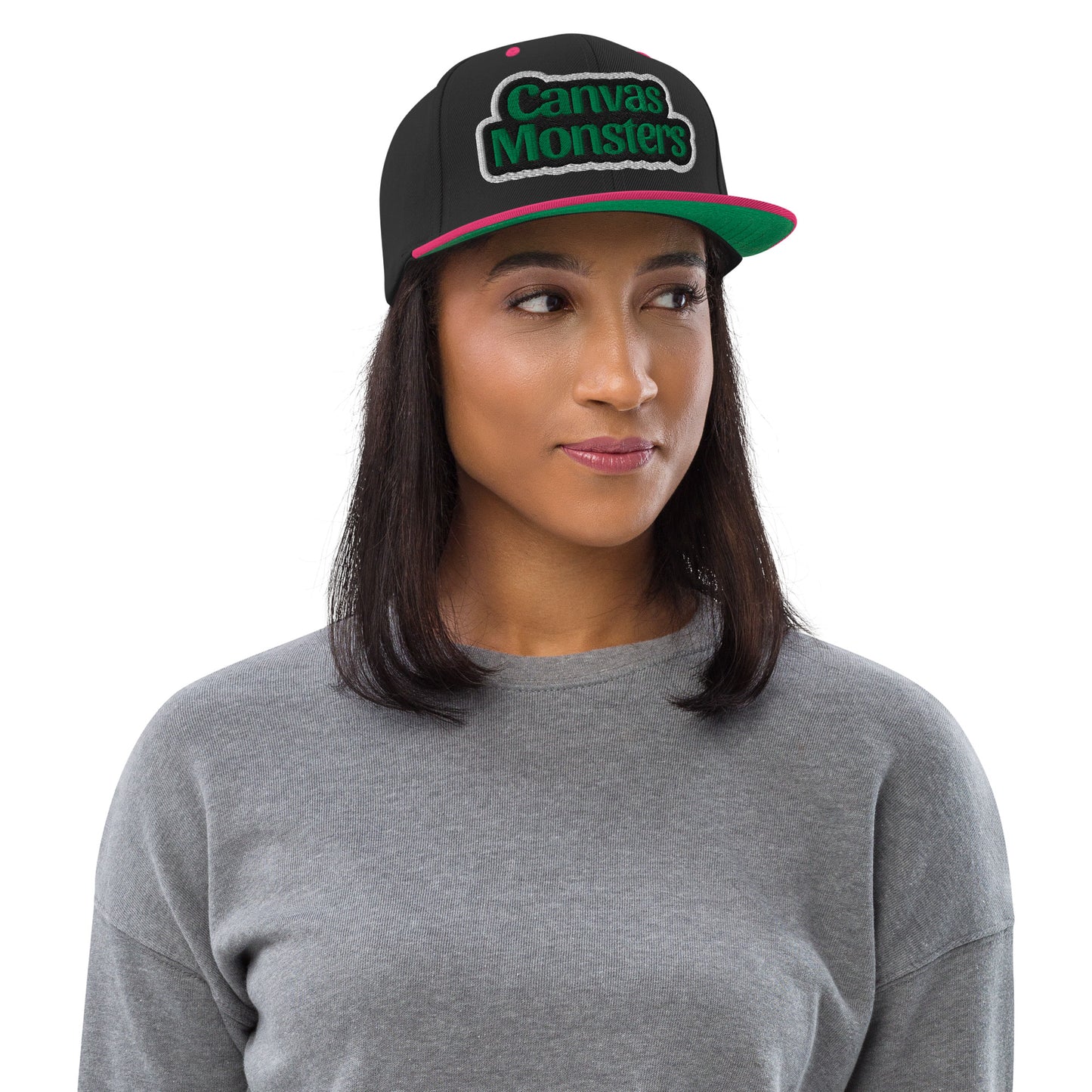 Woman wearing a black cap with 'Canvas Monsters' logo on a white background