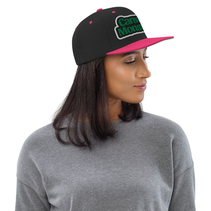 Person wearing a black and pink cap with 'Canvas Monsters' text on a white background
