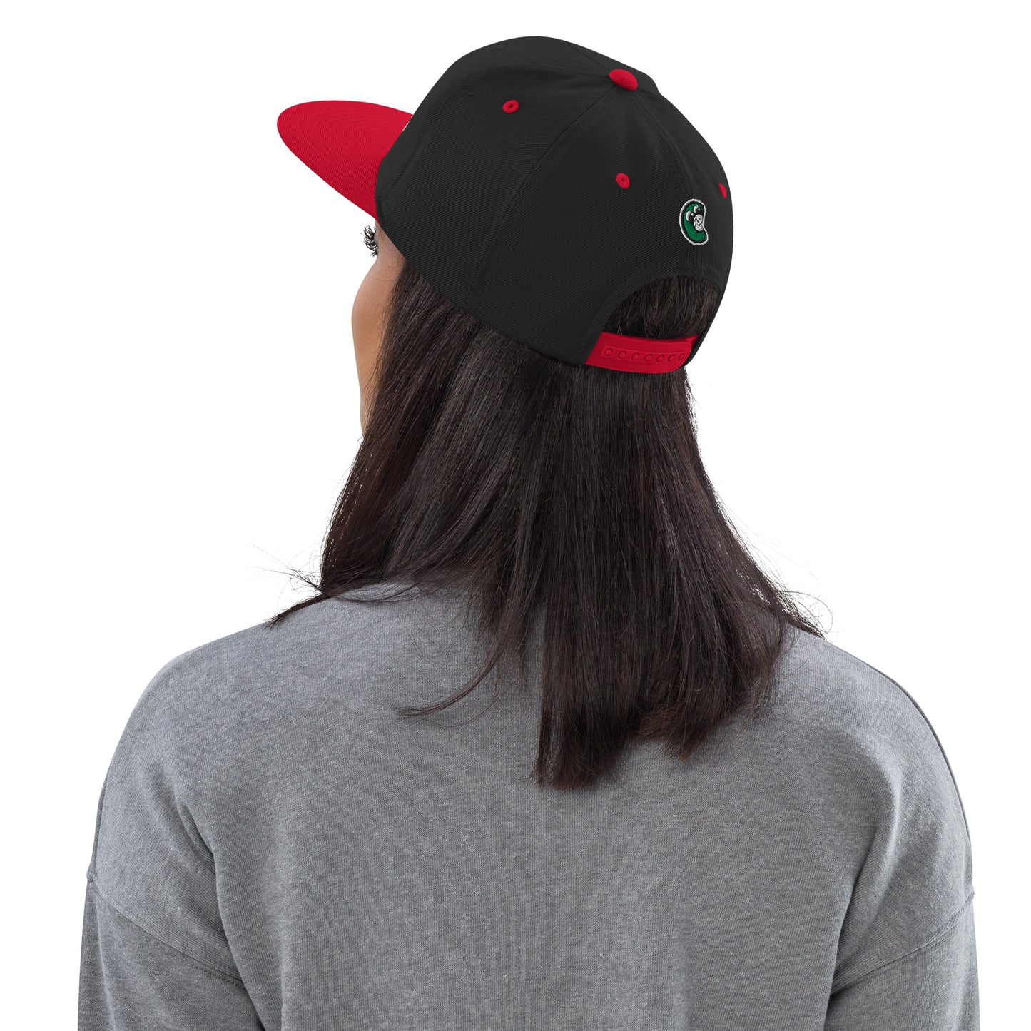 Person wearing a black and red cap with a logo on a white background