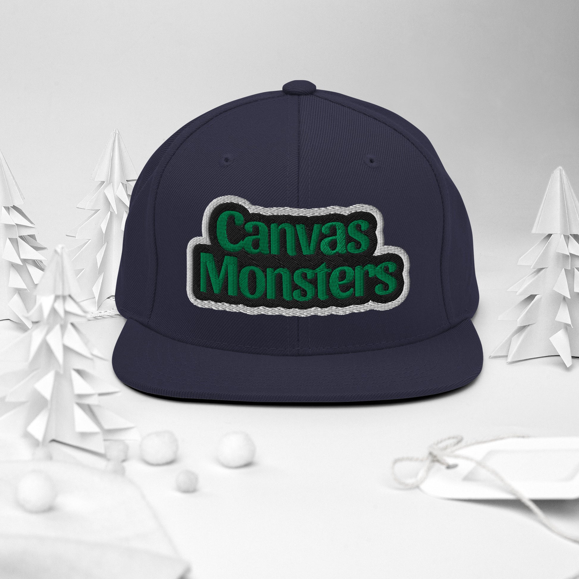 Navy blue cap with 'Canvas Monsters' text on a white background