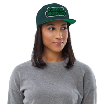 Woman wearing a green 'Canvas Monsters' cap on a white background