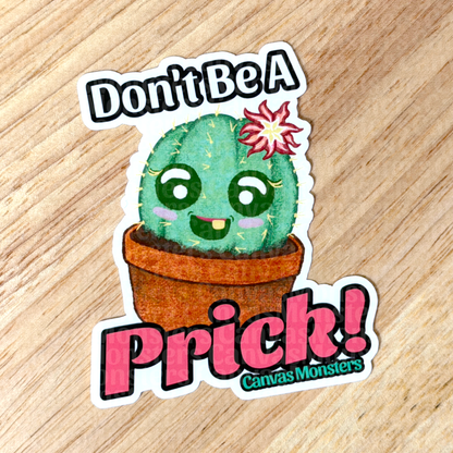 Sticker with a cactus character and text 'Don't Be A Prick!' on a wooden surface