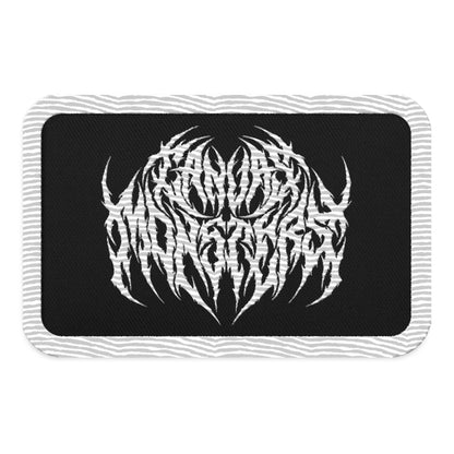 Embroidered patch with a white outline, black background and white embroidered design in metal lettering that reads "Canvas Monsters", all on a white background.