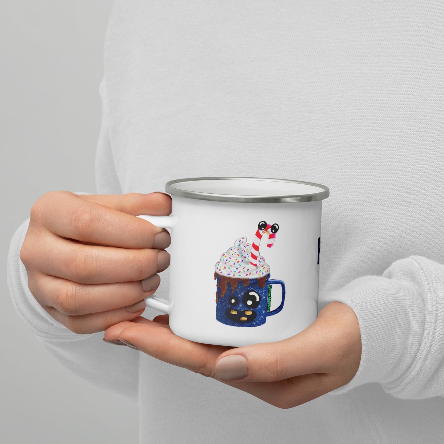 Person holding a white camper mug with a festive design on a plain background