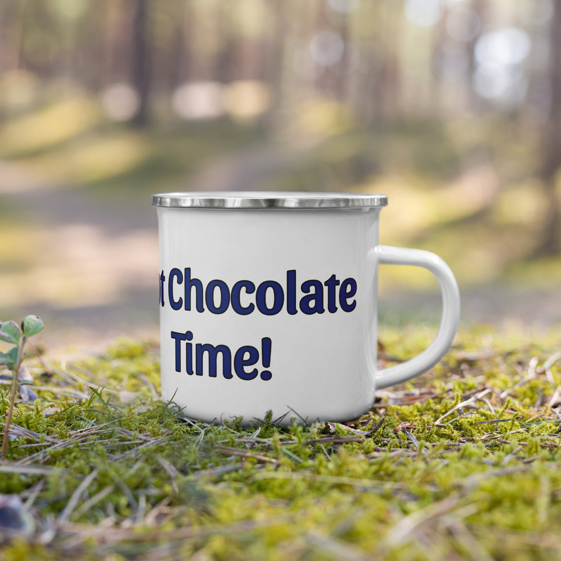 Mug with 'Hot Chocolate Time!' text on grass in a forest setting