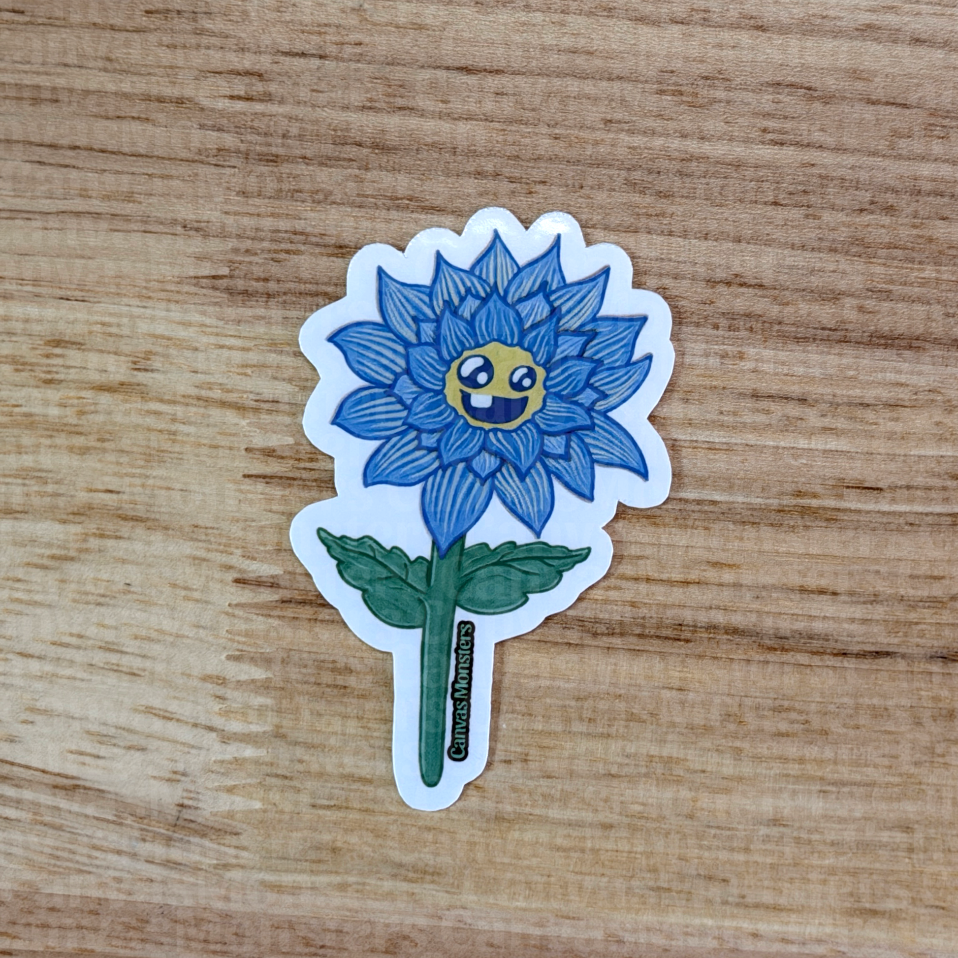 Sticker of a blue flower with a smiling face on a wooden surface