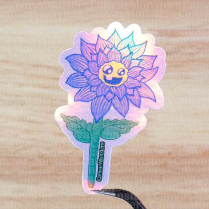 Holographic sticker of a blue flower with a smiley face on a wooden surface