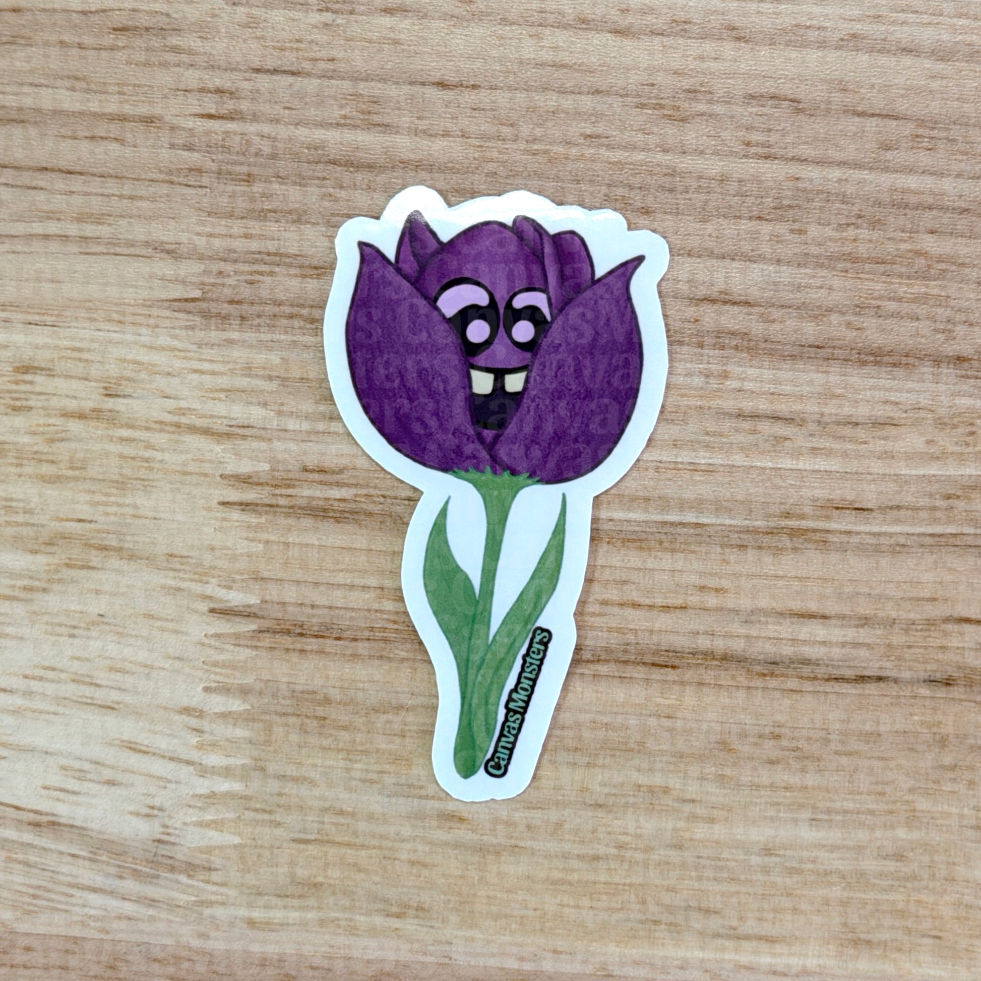 Sticker of a purple tulip with cartoon face on a wooden surface