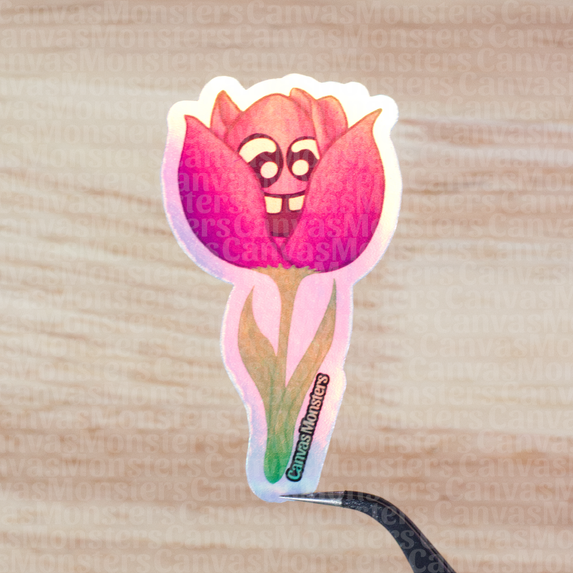 Holofoil sticker of a pink flower with a face on a wooden surface