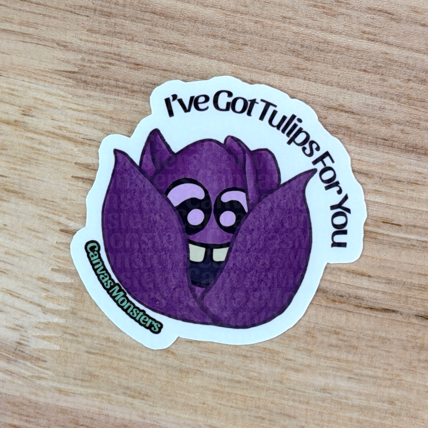 Purple tulip-shaped sticker with the text 'I've Got Tulips For You' on a wooden surface