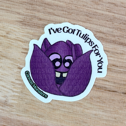Purple tulip-shaped sticker with the text 'I've Got Tulips For You' on a wooden surface