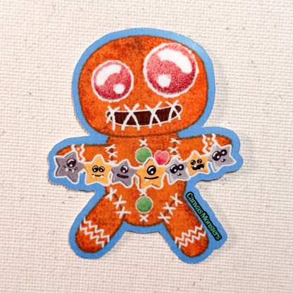 Glossy sticker of a gingerbread man-shaped cookie holding colorful star decorations on a textured beige background