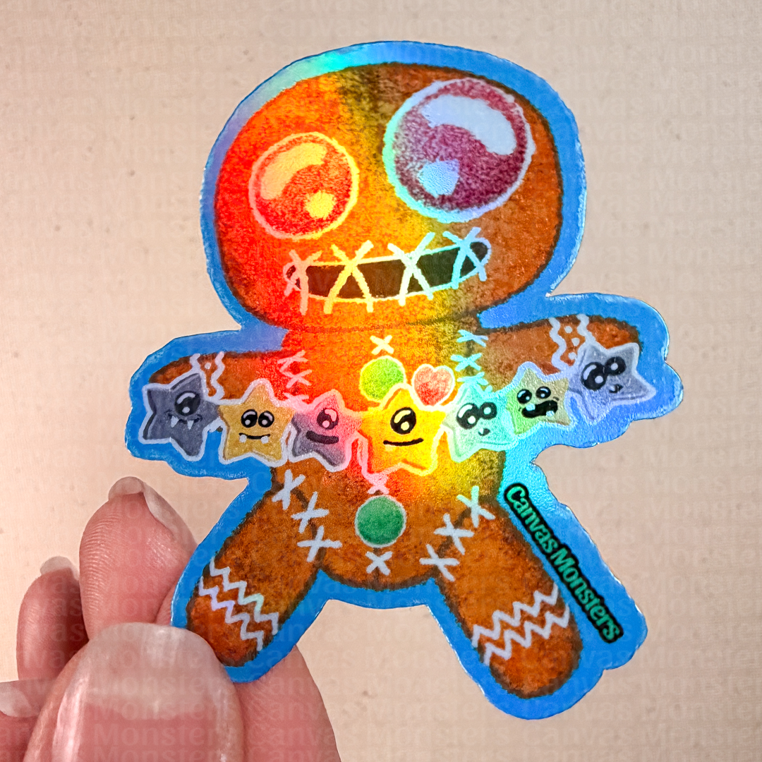 Holofoil sticker of a gingerbread man-shaped cookie holding colorful star decorations on a textured beige background